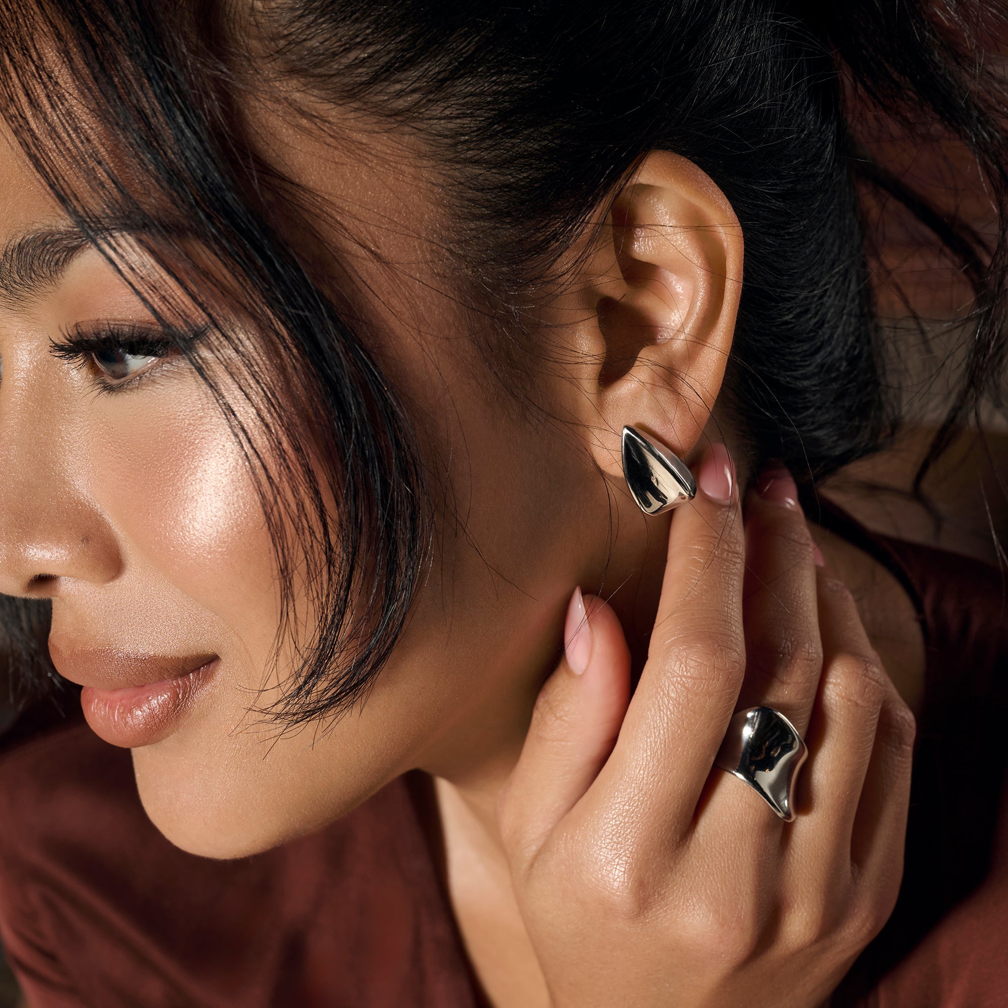 Silver stainless steel sculptural stud earrings with organic abstract design, hypoallergenic jewelry for sensitive ears, non-tarnish durable minimalist statement earrings, modern contemporary jewelry Canada.