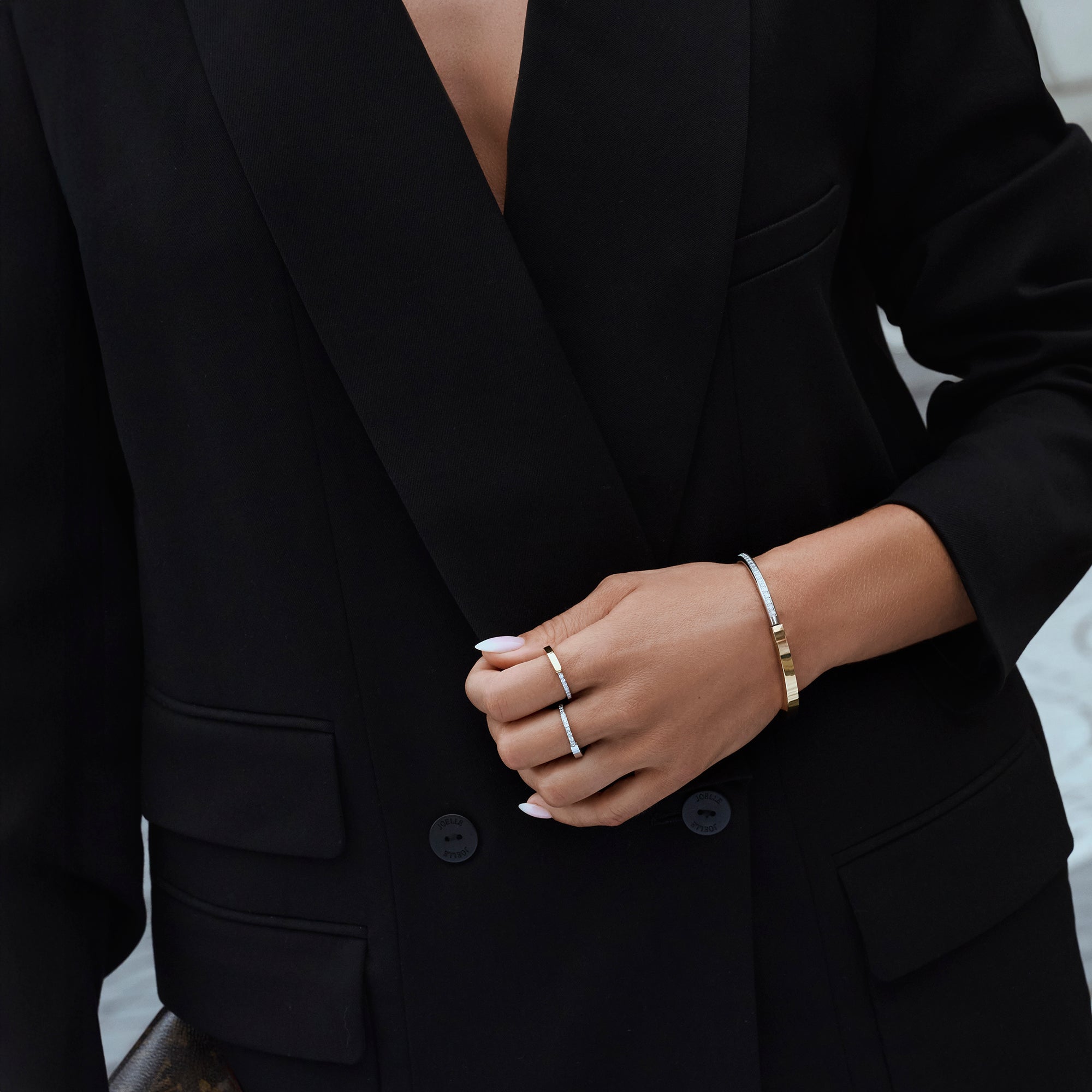 Silver stainless steel pavé cubic zirconia rings with two-tone gold and silver minimalist bangle bracelet, elegant modern jewelry styling, hypoallergenic non-tarnish durable everyday jewelry.
