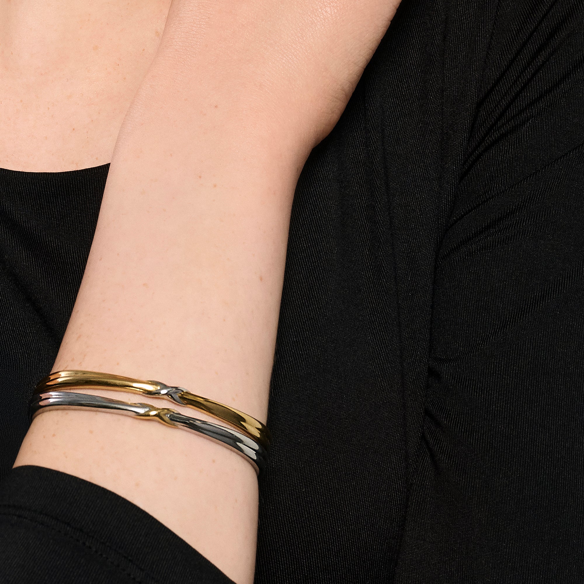 Two-tone stainless steel sculptural bracelet with twisted gold and silver design, modern minimalist jewelry, hypoallergenic non-tarnish durable bracelet, elegant everyday statement jewelry.